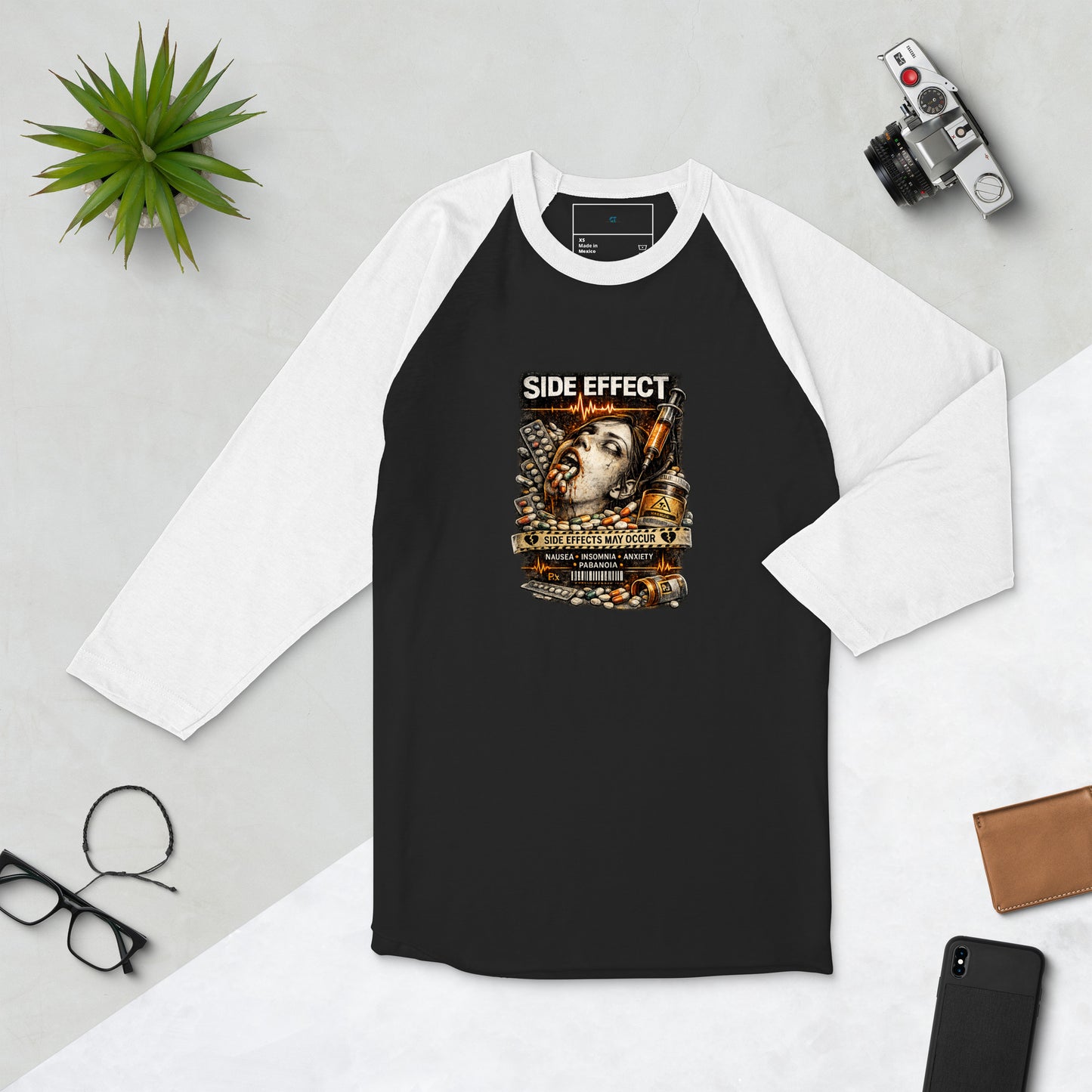 Close-up of Side Effect T-Shirt showing pill bottle artwork, warning label details, and side effect graphic design